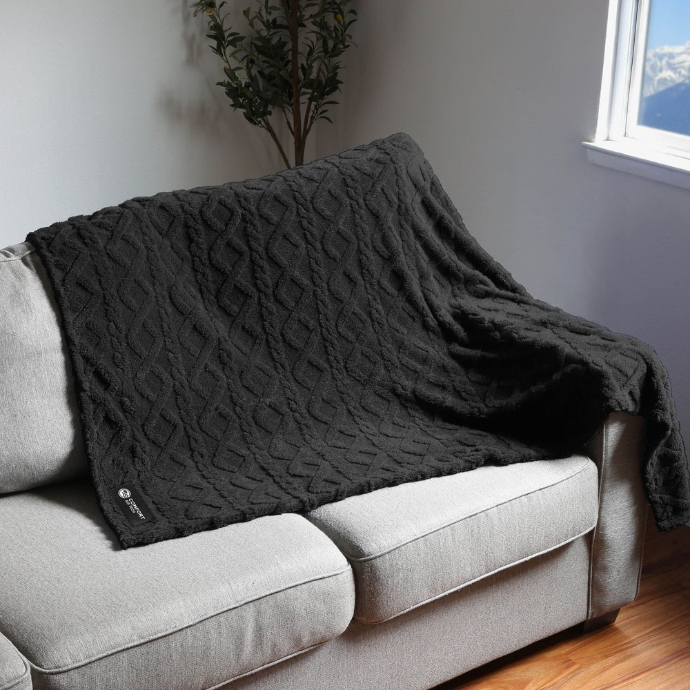 Dark fleece blanket draped over a sofa